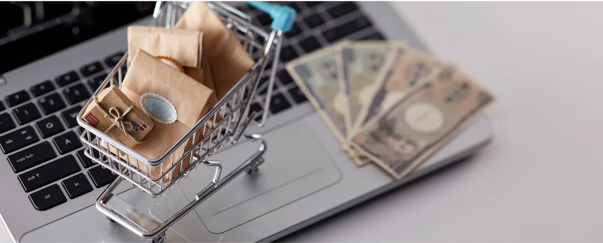 a tiny pushcart with gifts on top of a laptop keyboard reposted by Made for Freedom