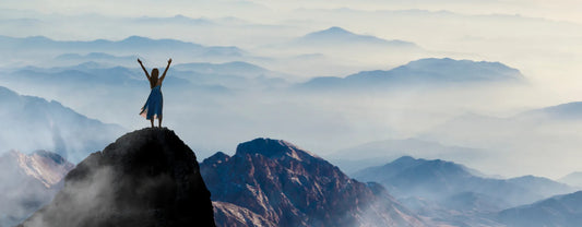 a woman on top of a mountain surrounded by a sea of clouds reposted by Made for Freedom