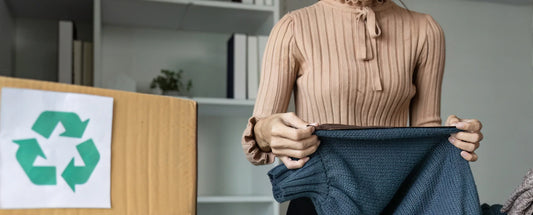 a woman checking out a clothing and a recycle box on the left