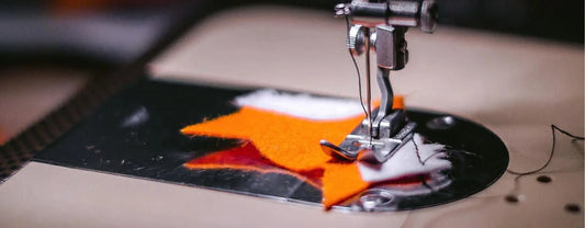pieces of fabric being sewn under a needle of a sewing machine reposted by Made for Freedom