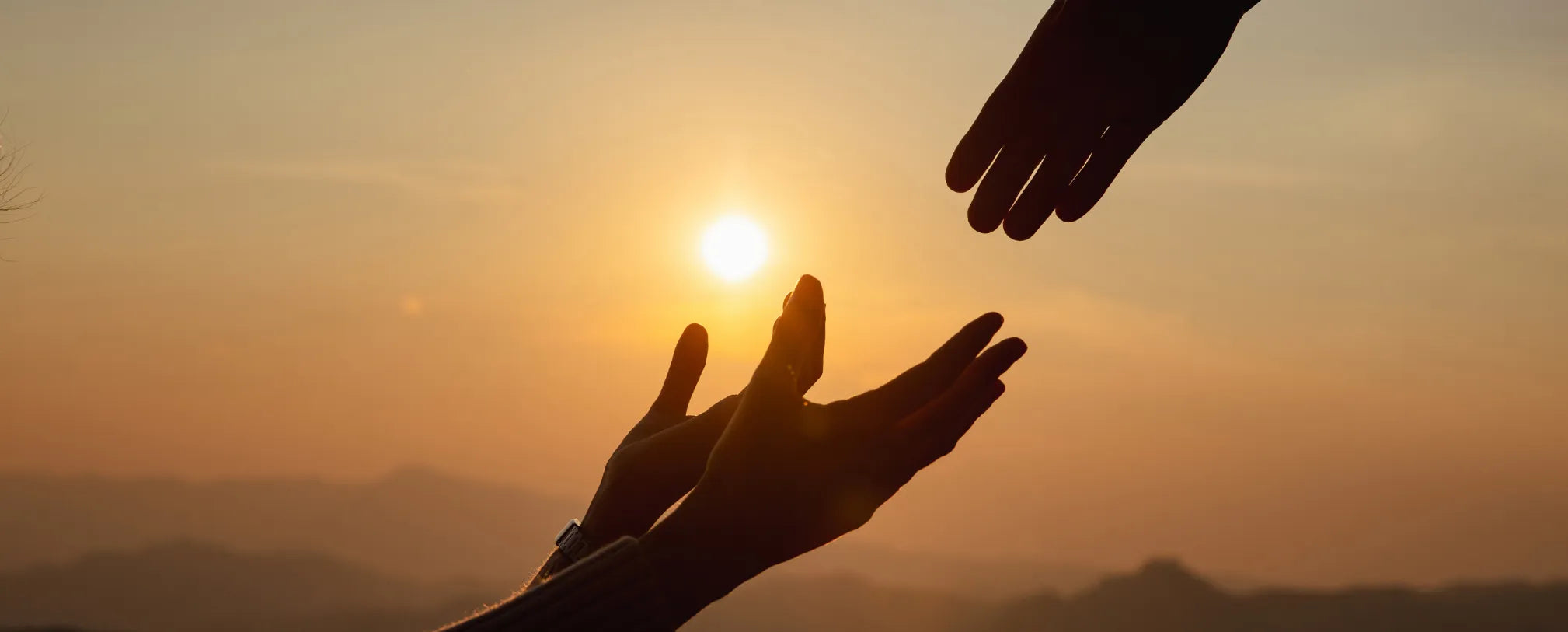 hands holding out to reach one another in front of the sunset reposted by Made for Freedom