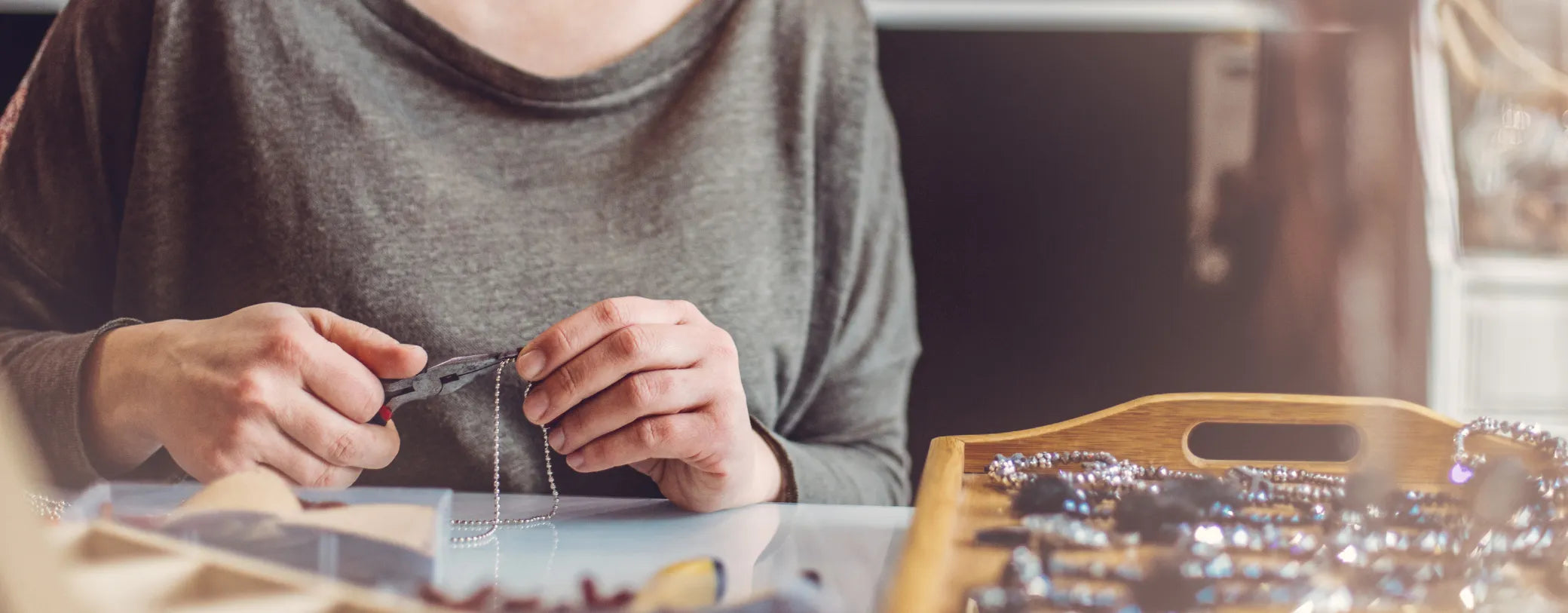 woman crafting jewelry on a table reposted by Made for Freedom