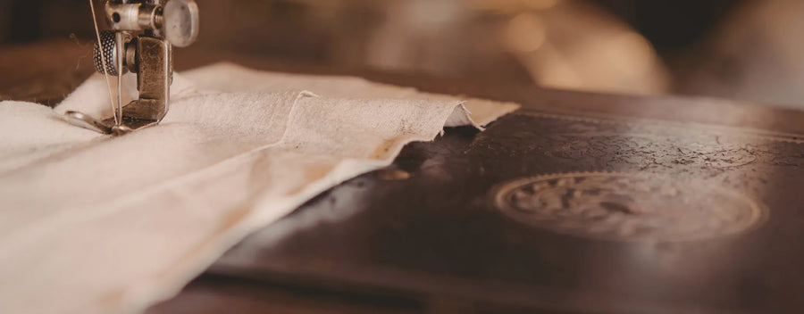 sewing machine needle going through a piece of white fabric reposted by Made for Freedom