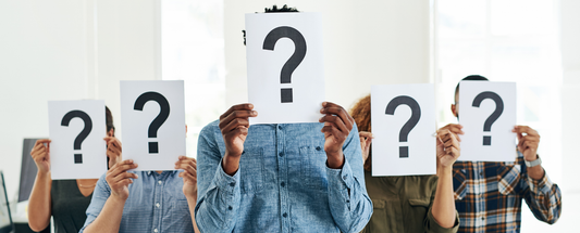 diverse group of people holding question mark signs in front of their faces, symbolizing uncertainty, identity, or ethical decision-making