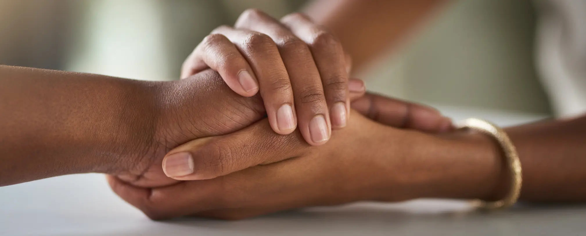 Close-up of one person gently holding another person’s hands, conveying comfort, compassion, emotional support, and human connection.