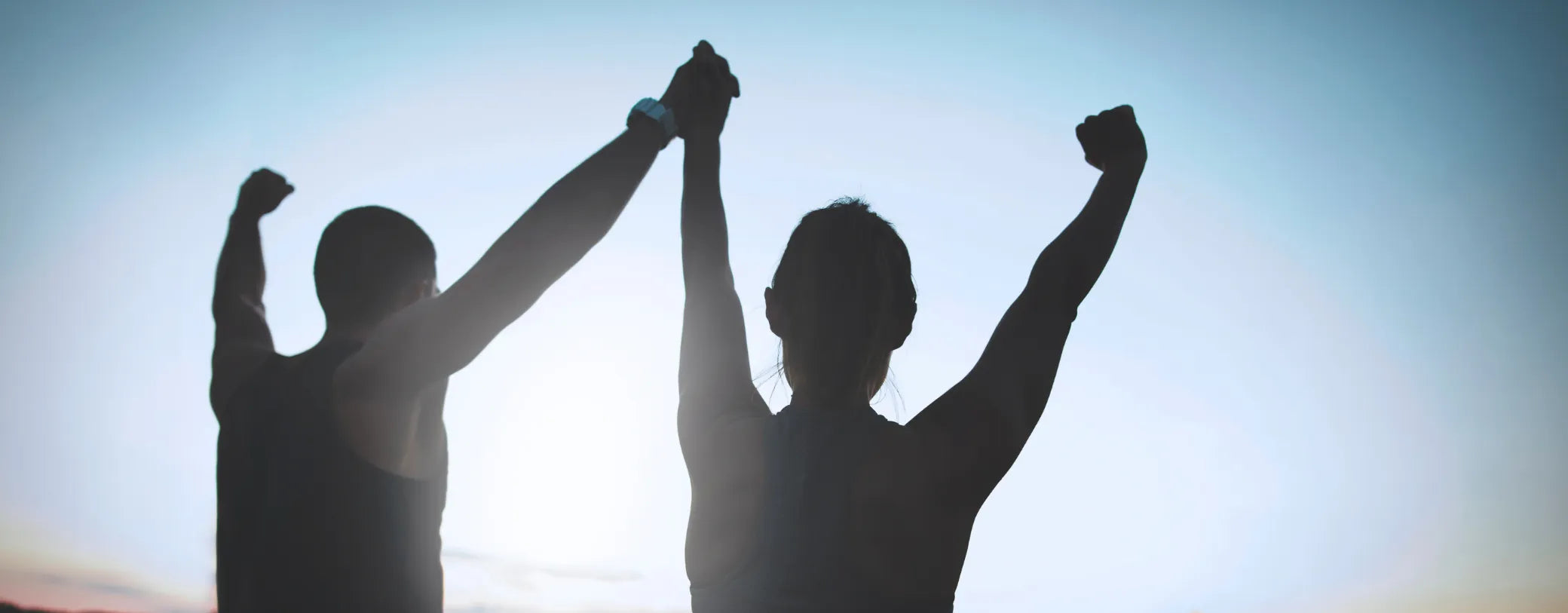 silhouette of a man and a woman celebrating with their arms up reposted by Made for Freedom