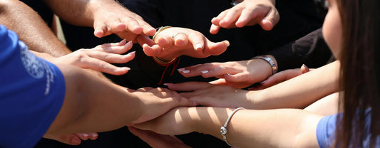 a group of people in a circle putting their hands together reposted by Made for Freedom