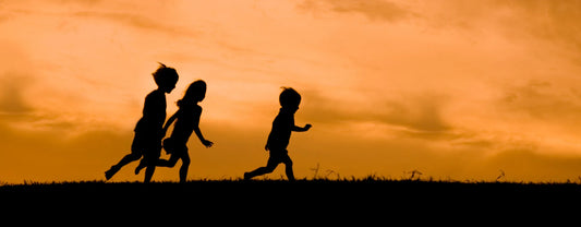 silhouette of children running through a field against orange skies reposted by Made for Freedom