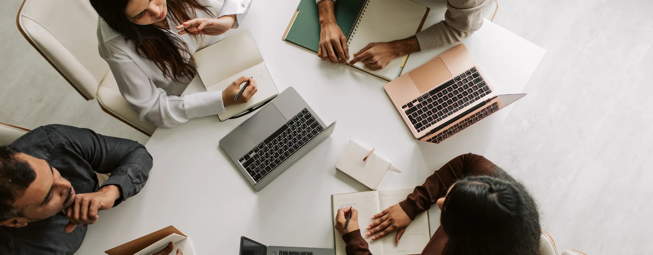 colleagues gathered around a desk on their computers reposted by Made for Freedom
