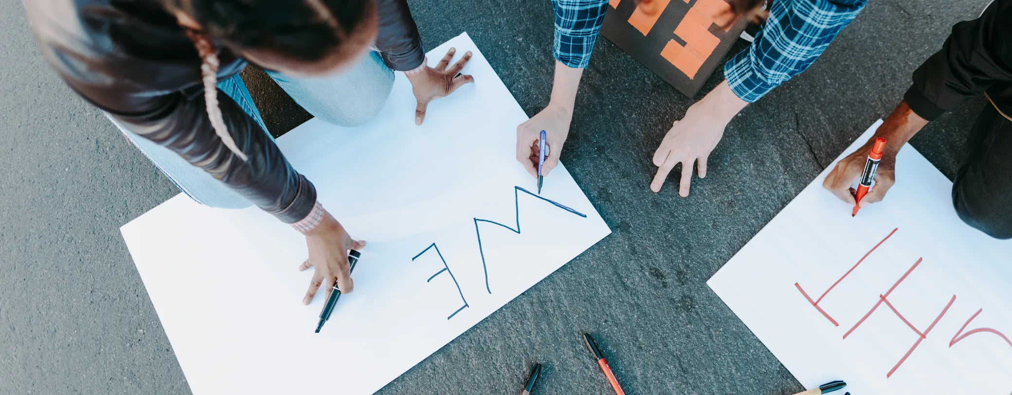 a group of people writing on signages for community event reposted by Made for Freedom