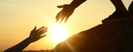 silhouette of two hands reaching out to one another in front of the sunset reposted by Made for Freedom