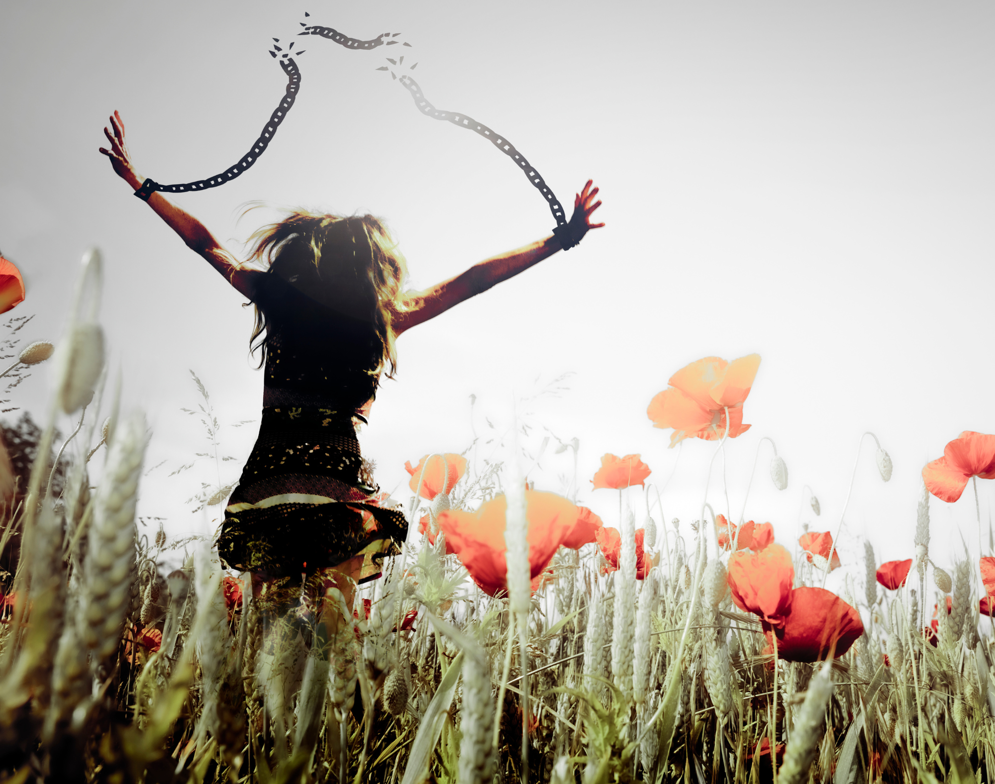 Woman breaking free from symbolic chains in a field of flowers, representing human trafficking survivor freedom and hope for a new life.